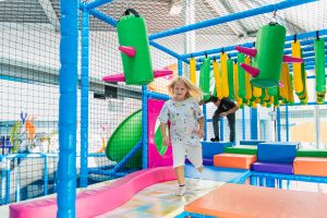 Kind läuft durch bunten Indoor-Spielplatzparcours bei Playworld Wien