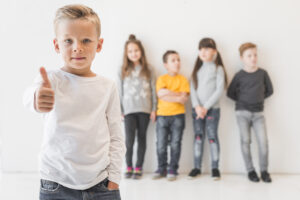 Ein Junge gibt Daumen hoch, während andere Kinder im Hintergrund stehen.