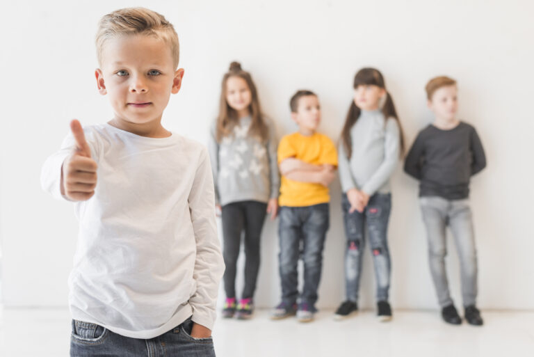 Ein Junge gibt Daumen hoch, während andere Kinder im Hintergrund stehen.